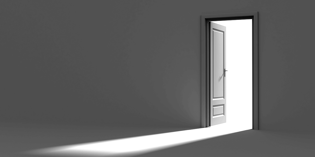 Open door letting light into a dark room.